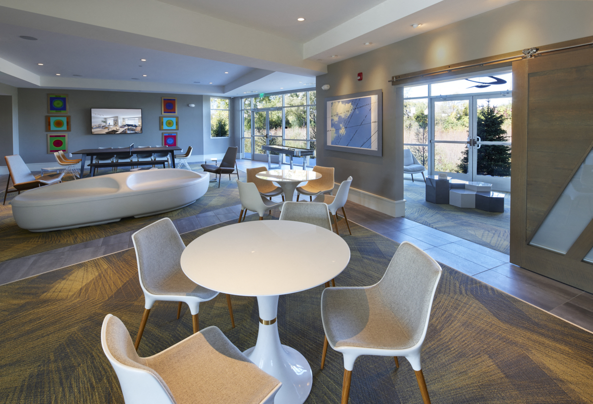a communal area with tables and chairs in a hotel lobby
